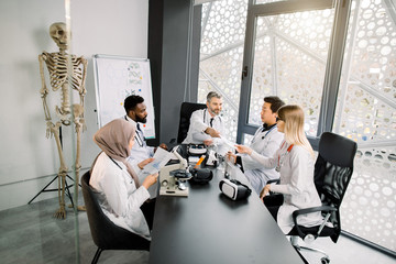 Multi ethnic group of medical students or young reseachers having a discussion during the...
