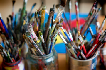 Fototapeta premium A lot dirty artist paint brushes in a bucket