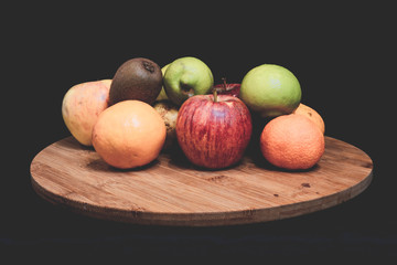 Fruta variada de colores con fondo negro  luces