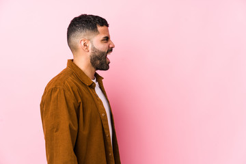 Obraz premium Young latin man against a pink background isolated shouting towards a copy space