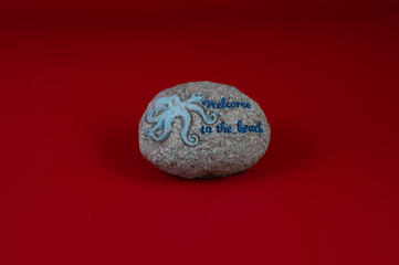 Round ornamental stone with octopus and welcome message, with gray background