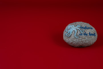 Round ornamental stone with octopus and welcome message, with gray background