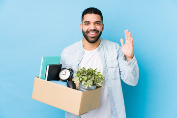 Young arabian man moving to a new home isolated receiving a pleasant surprise, excited and raising hands.