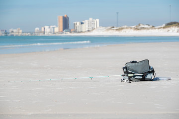 rod and reel lying in the beach sand