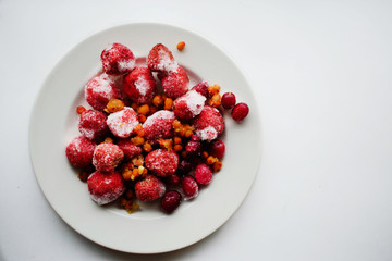 frozen berries strawberries sea buckthorn cranberries in a white plate