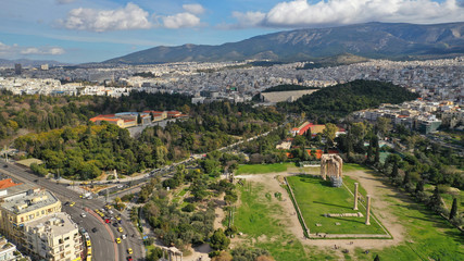 Aerial drone photo of famous column ruins of Temple of Zeus in the slopes of Acropolis hill and the Parthenon, Athens, Attica, Greece