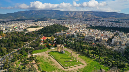 Obraz premium Aerial drone photo of famous column ruins of Temple of Zeus in the slopes of Acropolis hill and the Parthenon, Athens, Attica, Greece