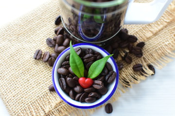 Coffee beans decorated with red heart and green leaves