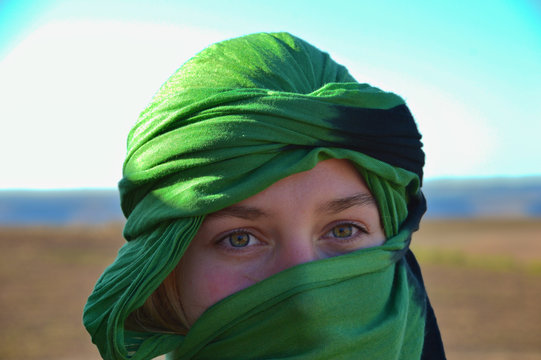 European woman covered in the green turban with only eyes showing  in Morocco