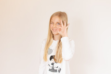 Blonde girl making gesture to the camera