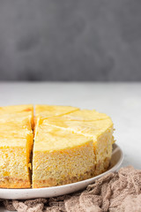 Pumpkin cheesecake with caramel sauce, light grey stone background. Selective focus.
