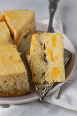 Pumpkin cheesecake with caramel sauce, light grey stone background. Selective focus.