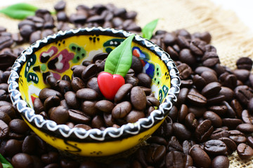 Coffee beans decorated with red heart and green leaves