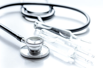 doctor's office table with vials and stethoscope white background