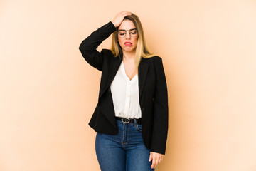 Middle age business woman isolated on beige background being shocked, she has remembered important meeting.