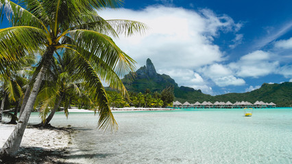 White sand beach and small yelow boot,   active vacation in Tahiti, French Polynesia. View of Mount Otemanu, luxury holiday.
