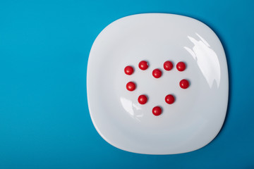 White plate with heart-shaped sweets on a blue background