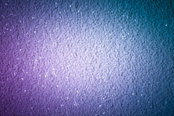 A shiny background with a dark vignette on the edges, a bright blue sheet of paper with sparkling sequins