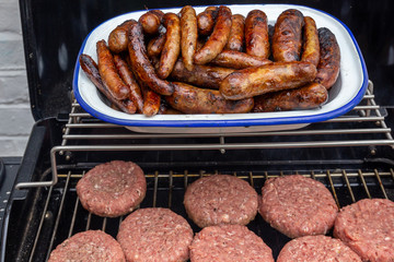 Burgers and sausages on an outdoor garden barbecue
