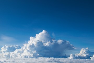 Fluffy clouds (Cumulonimbus) at high altitude over deep blue sky. Heaven, freedom, purity concept.