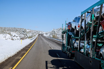 Naklejka premium Truck transporter cars carrier at the road winter in the mountains