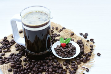 Coffee beans, accompanied by cup of hot coffee