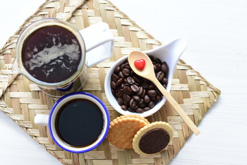 Coffee beans, accompanied by cup of hot coffee