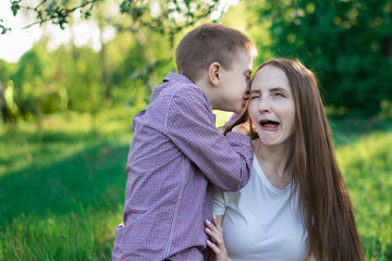 Young mother having fun with son. Positive mom with child in the Park. Wacky facial expression.