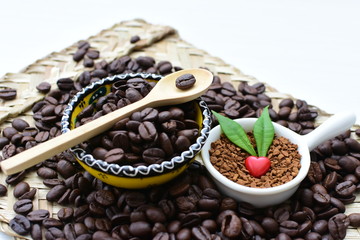 Coffee beans decorated with red heart and green leaves