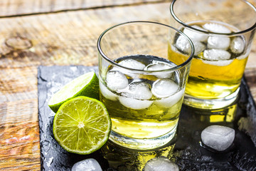 glass of whiskey on wooden background