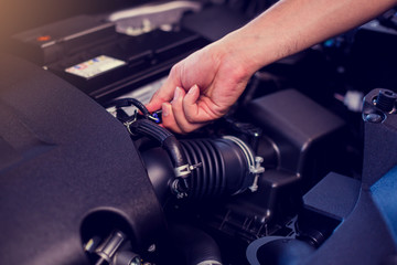 The connectors of car engine with blurry hand of mechanic to checking. Checking the engine by yourself. Car quality inspection in the automobile industry. Quality Control Concept. (QC)