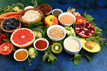 Fototapeta na wymiar Healthy food clean eating selection: fruit, vegetable, seeds, superfood, cereals, leaf vegetable on rustic background
