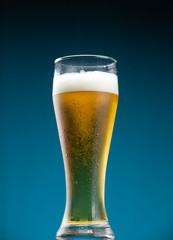 Glass of beer covered with numerous drops of water condensate