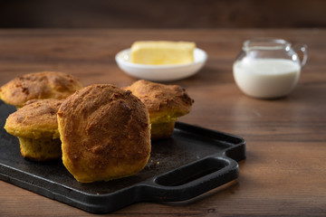 HANDCRAFTED CORN BREAD, ECUADORIAN KITCHEN RECIPE, SERVED ON WOODEN TABLE, WITH MILK AND BUTTER