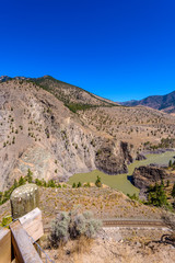View of beautiful landscape in the Rocky Mountains with fresh blue and green mountain river water and mountain tops in the background on a sunny day with blue sky in springtime.