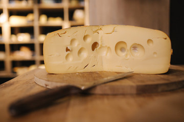 Cheese maasdam om wooden board with knife for cheese