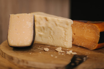 Different types of aged cheese on wooden board