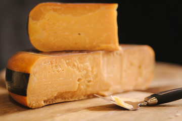 Cheese of wooden table in cheese store. Piese of aged cheese