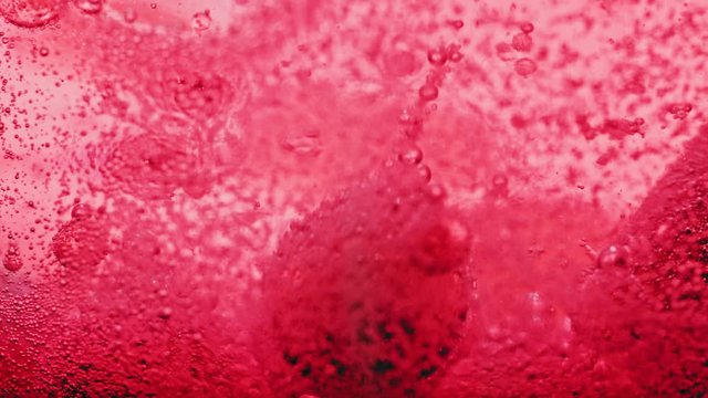 macro shot of red bubbles dripping and moving around in bright red water