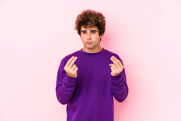 Young caucasian man against a pink background isolated showing that she has no money.