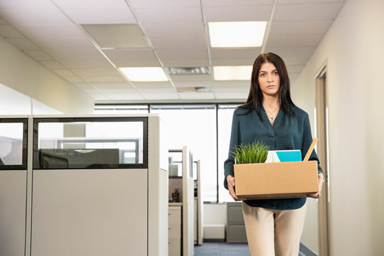 A Young Female Employee Carrying Office Possessions After Being Laid Off. , Jacksonville, Florida, USA