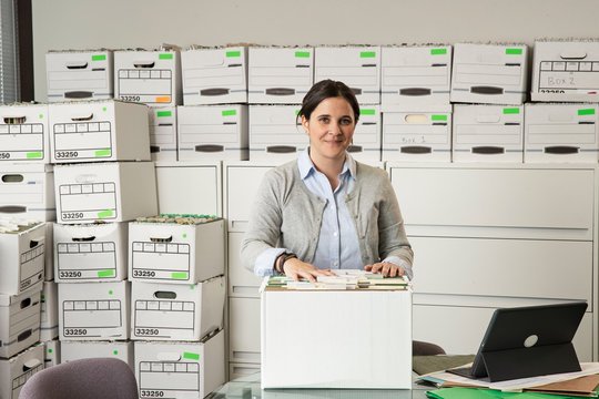 Portrait of a woman surrounded by boxes of office files., Jacksonville, Florida, USA
