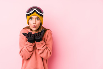 Young caucasian woman wearing a ski clothes isolated folding lips and holding palms to send air kiss.