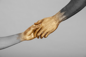 Desaturated shot of mixed-race woman and Black man with gold painted hands holding hands., Dallas, Texas, USA