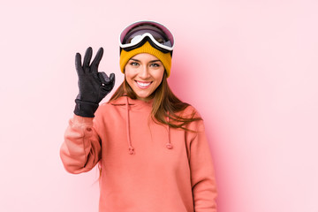 Fototapeta premium Young caucasian woman wearing a ski clothes isolated cheerful and confident showing ok gesture.