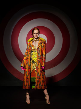 Portrait of a young woman standing in front of large hand painted Bulls-eye target, Dallas, Texas, USA