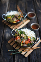 Chinese cuisine.  chinese beef in spicy sauce with rice and  vegetables.  Colorful stir fry in a wok.