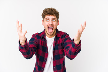 Fototapeta premium Young blond curly hair caucasian man isolated screaming to the sky, looking up, frustrated.