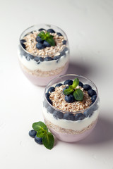 two blueberry yogurt in glasses on a white table, top view, ingredients for cooking diet food
