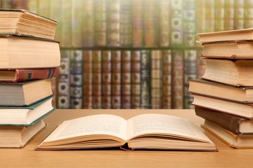 Stack open old books on wooden desk